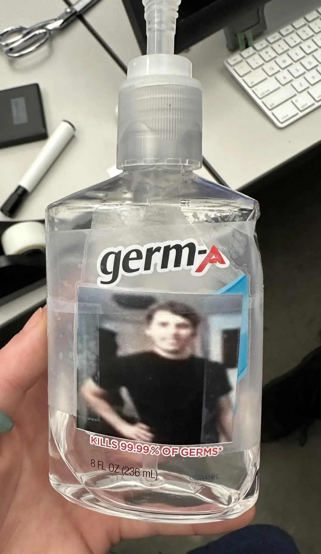 hand sanitiser but with a picture of Jerma and text "germ-a" taped on top of it. (kills 99.99% of germs*)